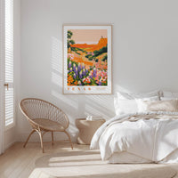 a bedroom with a large framed poster of a colorful landscape of flowers hanging on the wall above a bed with white bedding.