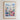 The image is a framed poster depicting a colorful and vibrant flower market in a city, with buildings, flowers, and greenery surrounding the scene.