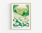 A framed poster depicting a scenic view of a flower garden in Missouri, with a large arch in the distance.