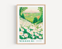 A framed poster depicting a scenic view of a flower garden in Missouri, with a large arch in the distance.