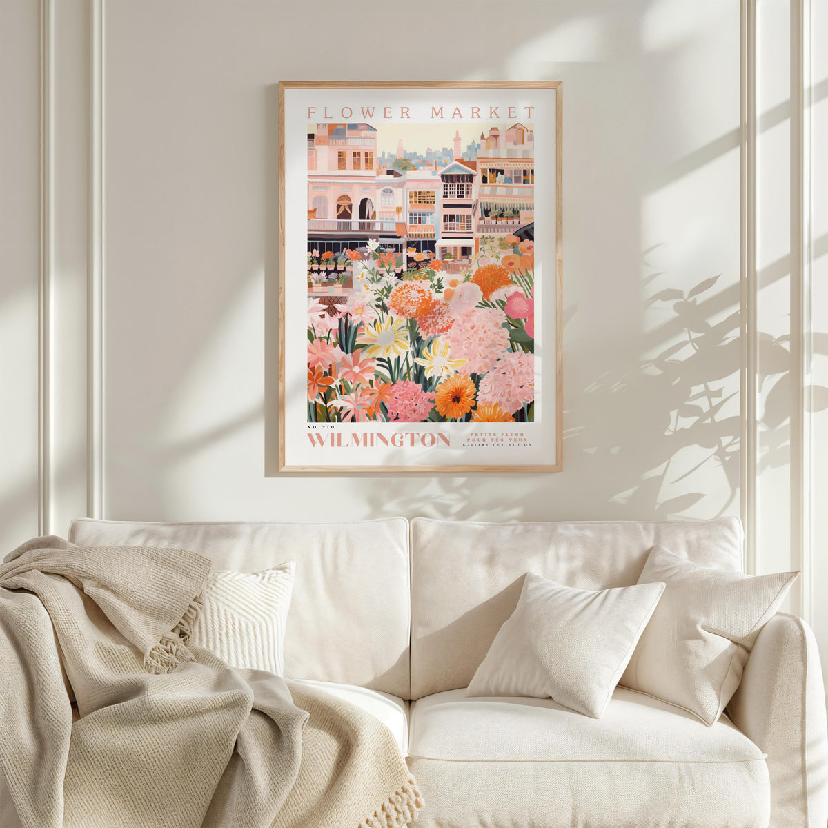 A framed poster of a flower market in Wilmington, featuring a colorful illustration of buildings and flowers.