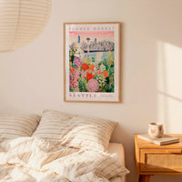 a bedroom with a framed poster of a cityscape hanging on the wall above a bed with striped pillows.