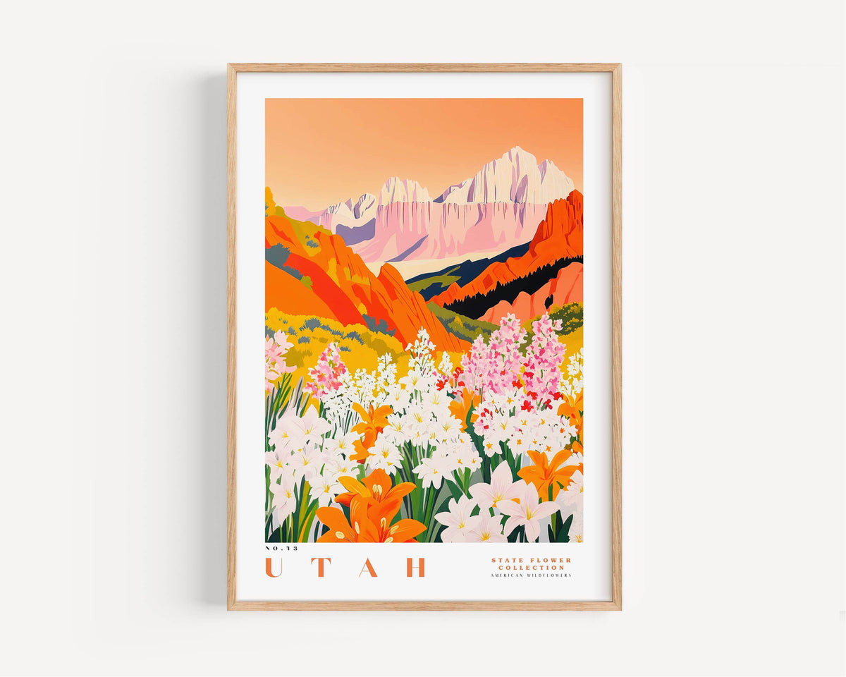 A framed poster depicting a vibrant landscape with mountains, flowers, and a warm, orange sky.