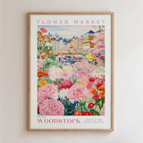 The image is a framed poster depicting a vibrant and colorful flower market in Woodstock, New York.