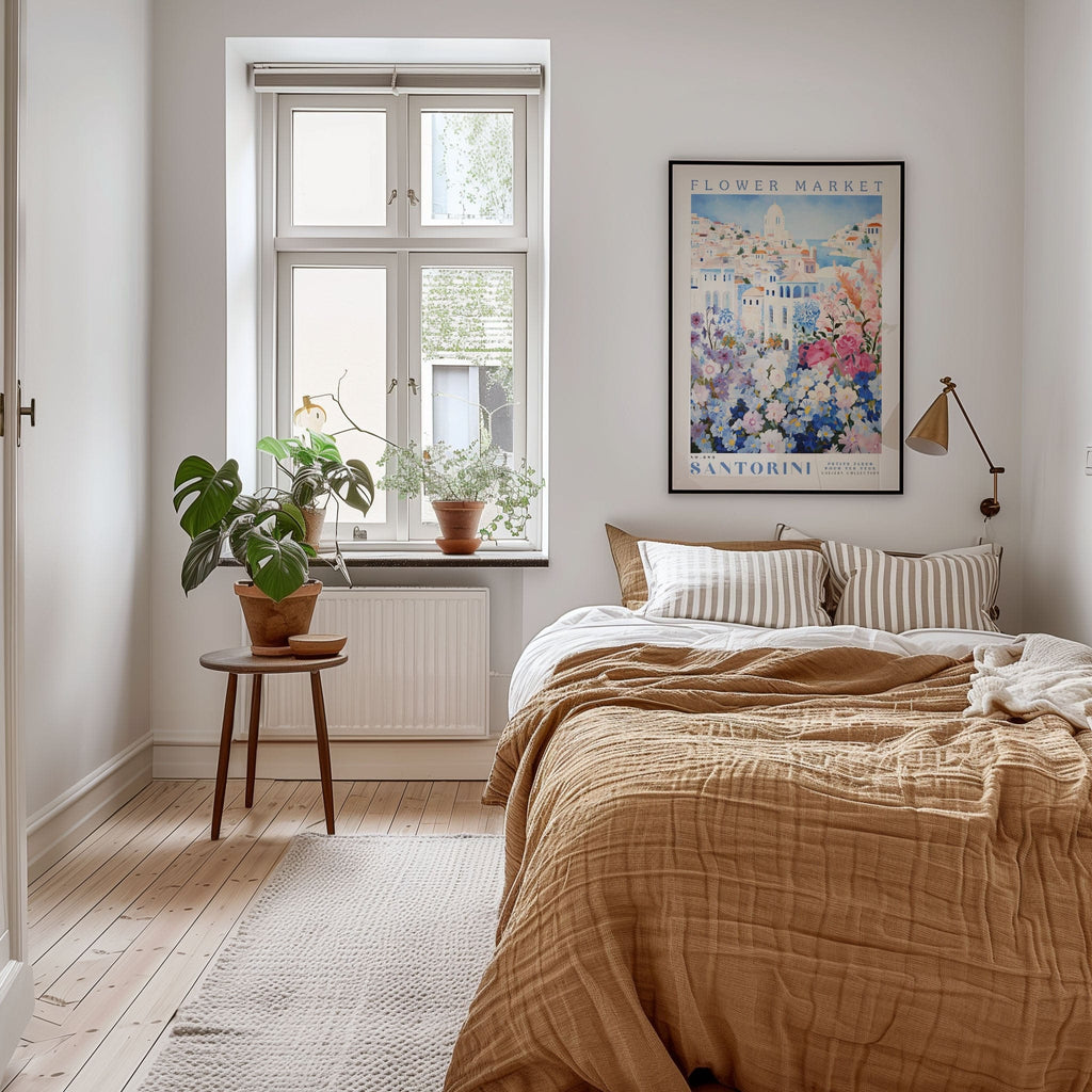 A cozy bedroom with a large bed, a wooden nightstand, and a potted plant. The room has a window with a view of a city, and a framed poster of a flower market on the wall.