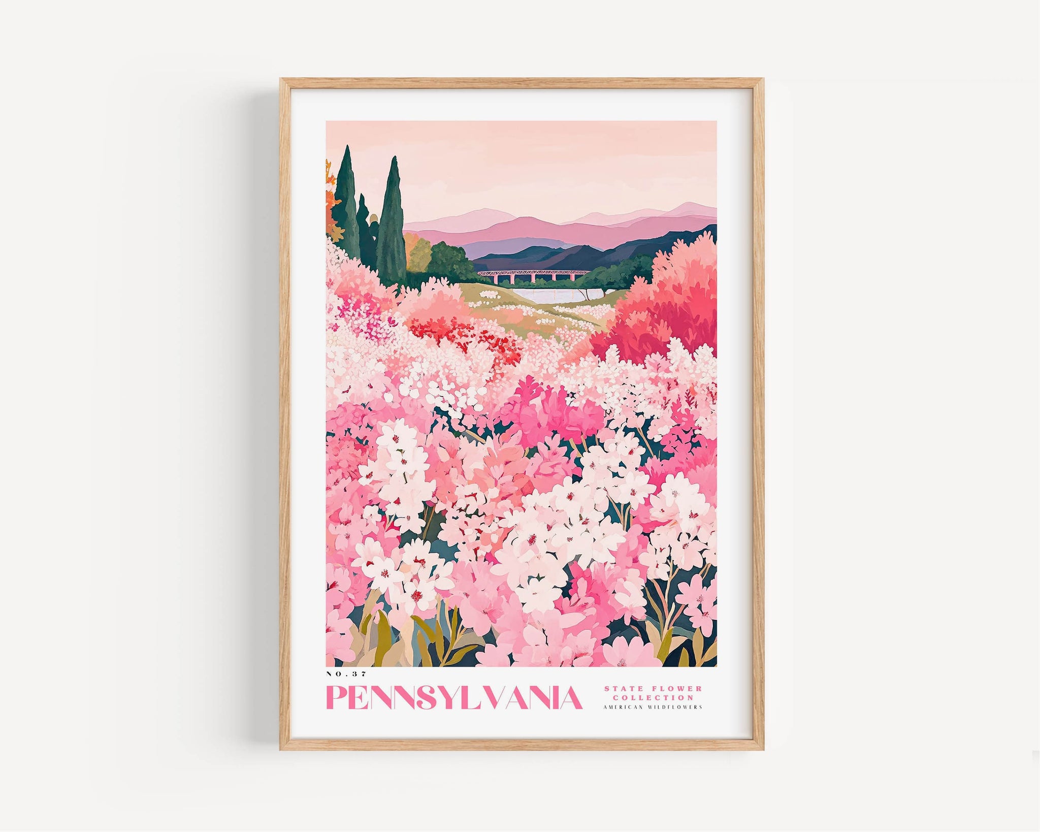 A framed poster depicting a scenic landscape with a field of pink flowers, mountains in the background, and a bridge in the distance.
