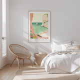 a serene bedroom scene with a large bed, a woven chair, and a framed poster of a beach landscape hanging on the wall.