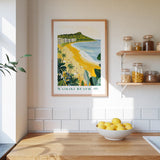 a framed poster of Waikiki Beach hanging on a wall above a kitchen counter with a bowl of lemons on it.