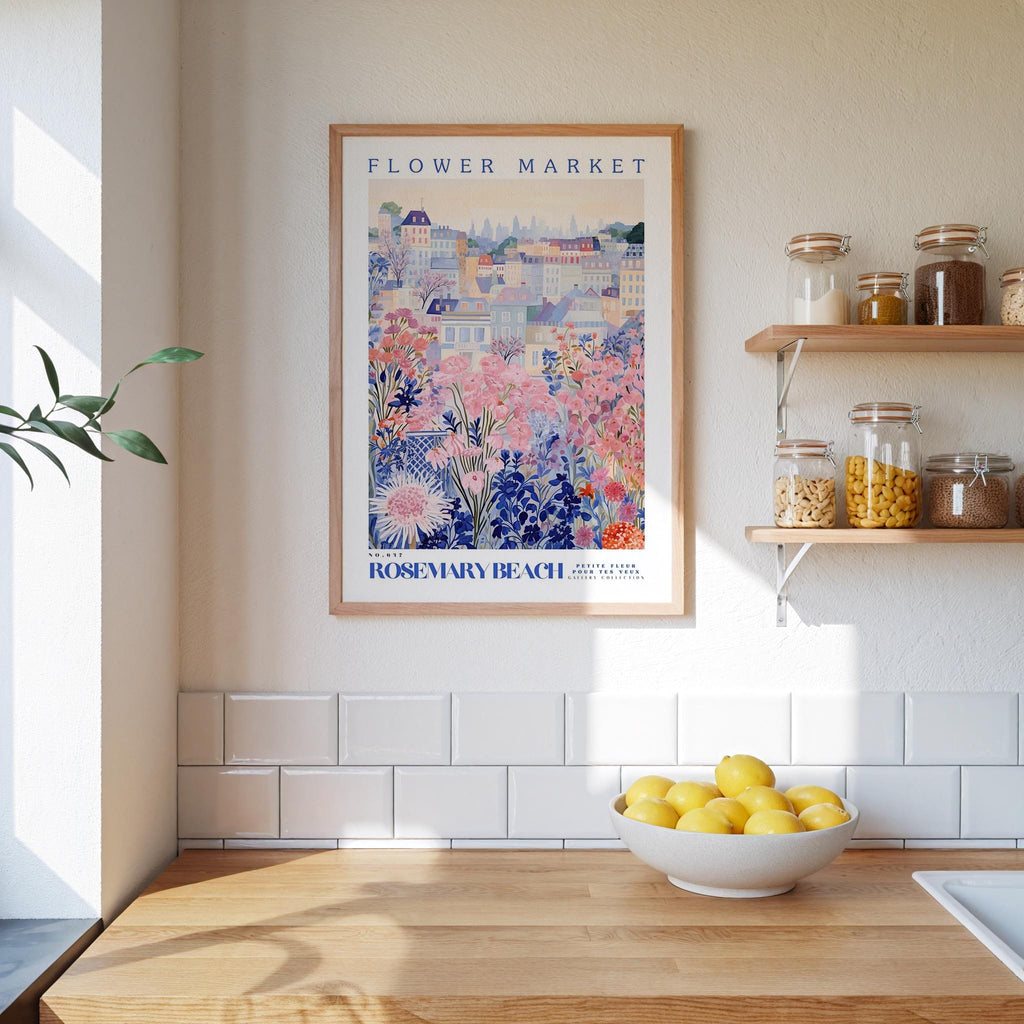 a kitchen scene with a framed poster of a colorful floral scene hanging on the wall above a wooden countertop with a bowl of lemons.