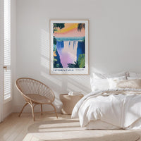 a bedroom with a large poster of Victoria Falls hanging on the wall, a woven chair, and a white bed with a beige blanket.