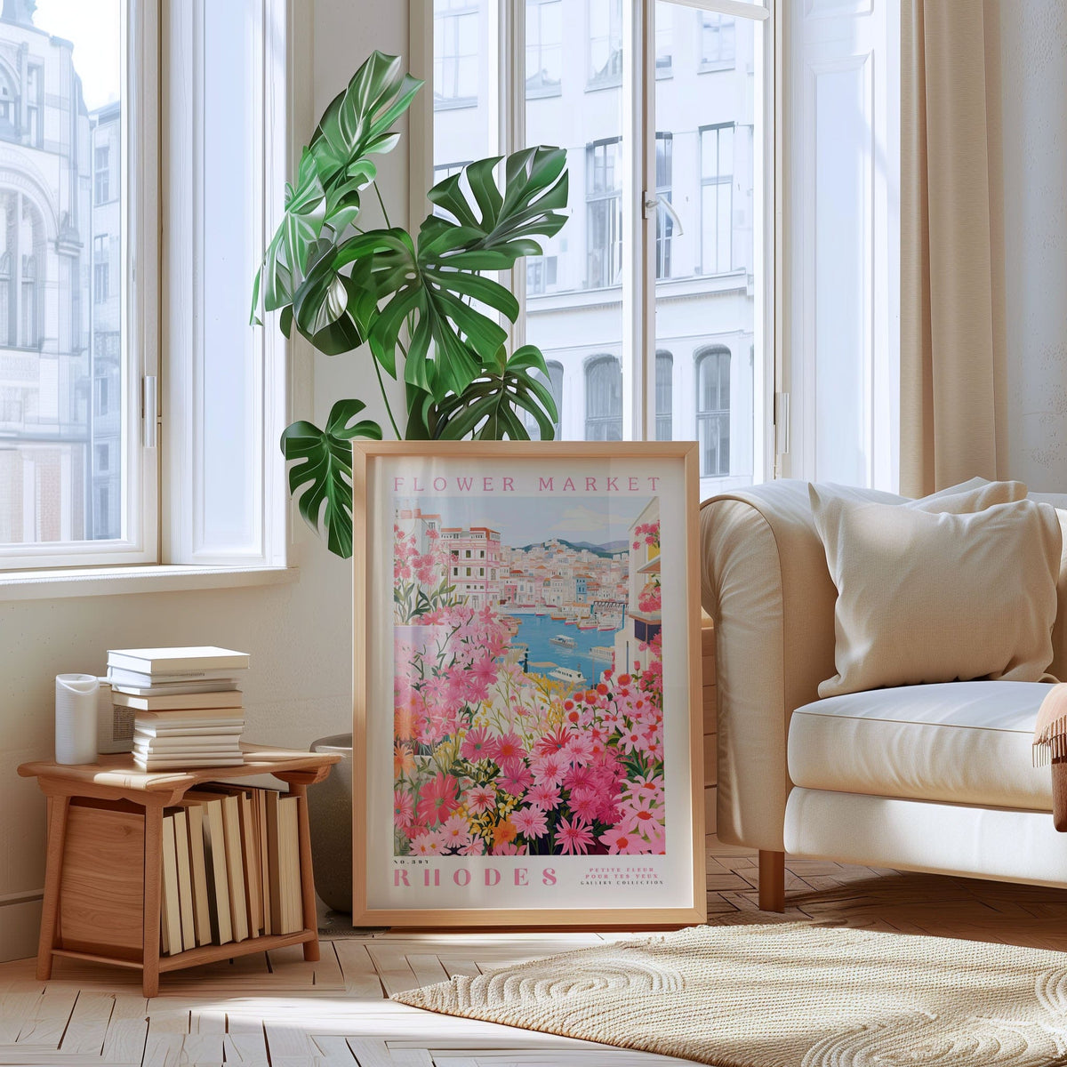 a living room with a large window, a framed poster of a flower market in Rhodes, a stack of books, a white sofa, and a potted plant.