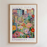The image is a framed poster depicting a vibrant and colorful flower market in Eindhoven, Netherlands.