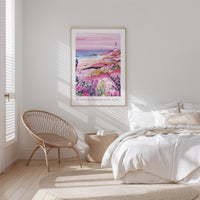 a serene bedroom scene with a large bed, a woven chair, and a framed poster of a beach landscape hanging on the wall.