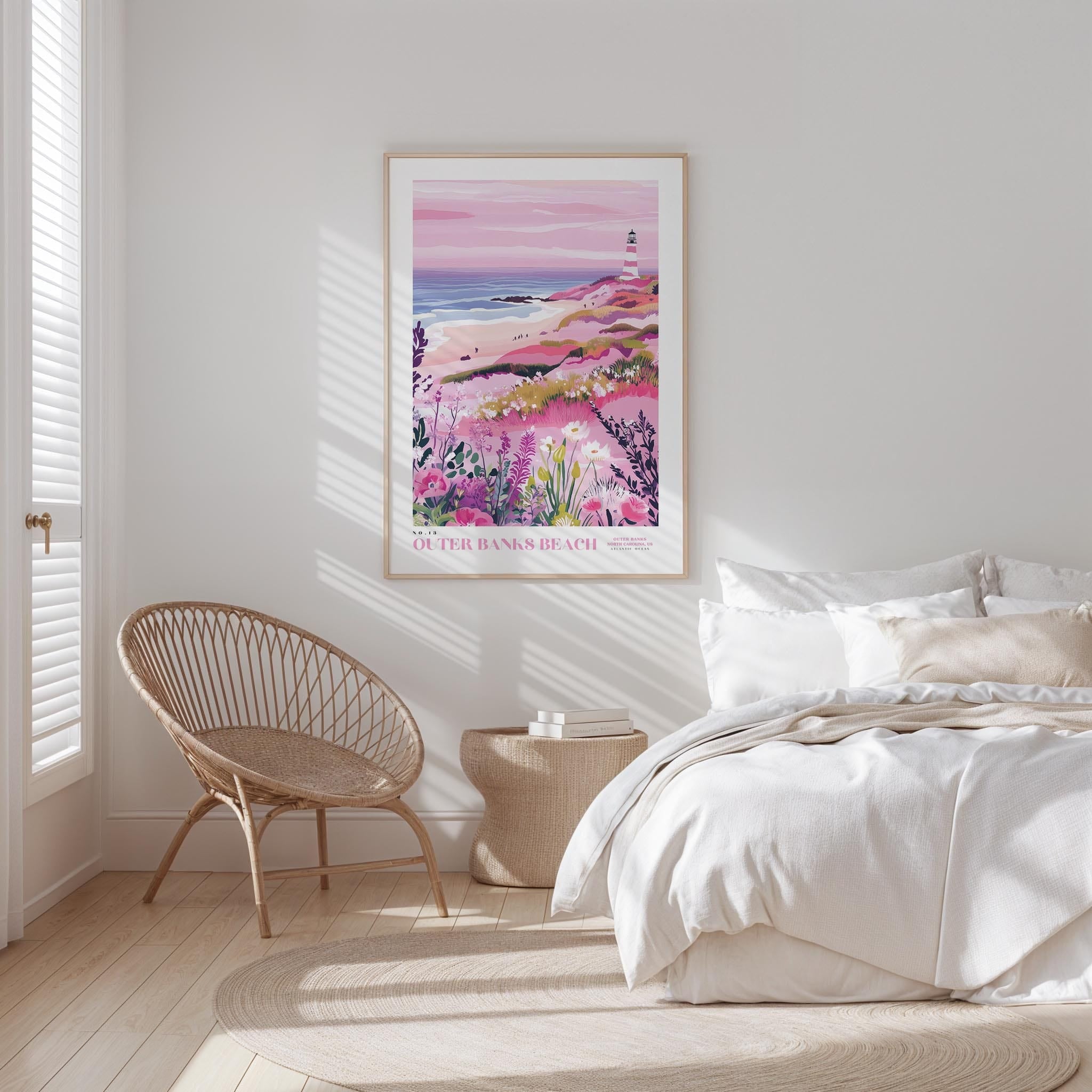 a serene bedroom scene with a large bed, a woven chair, and a framed poster of a beach landscape hanging on the wall.