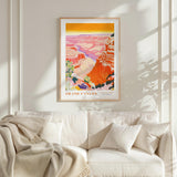 a framed poster of the Grand Canyon hanging on a wall above a white couch with a blanket draped over it.