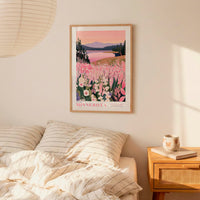 a bedroom scene with a framed poster of a scenic landscape hanging on the wall above a bed with striped pillows.