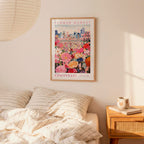 a bedroom scene with a framed poster of a cityscape and a bed with striped pillows.