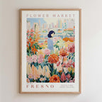 The image is a framed poster depicting a woman standing amidst a colorful garden filled with various flowers.
