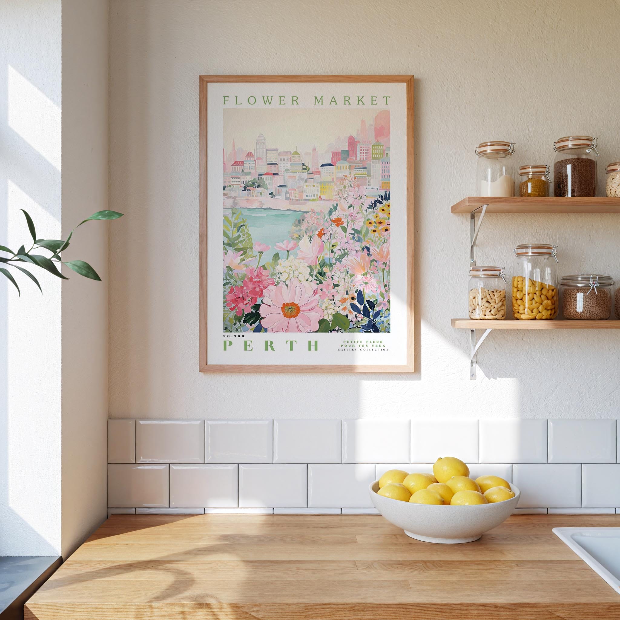 a kitchen scene with a framed poster of a cityscape and a bowl of lemons on a wooden countertop.