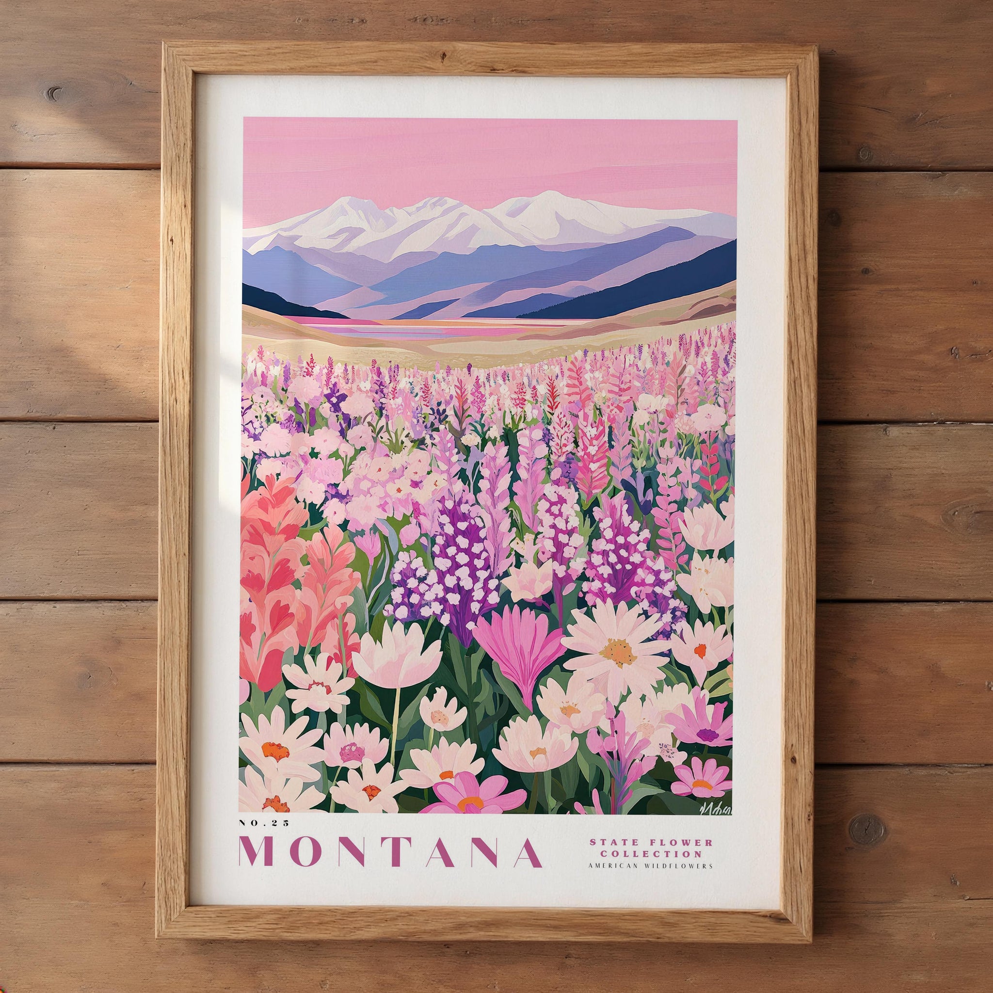 A framed poster depicting a vibrant field of wildflowers in Montana, with snow-capped mountains in the background.