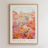 The image is a framed poster depicting a vibrant and colorful flower market scene with various types of flowers and buildings in the background.
