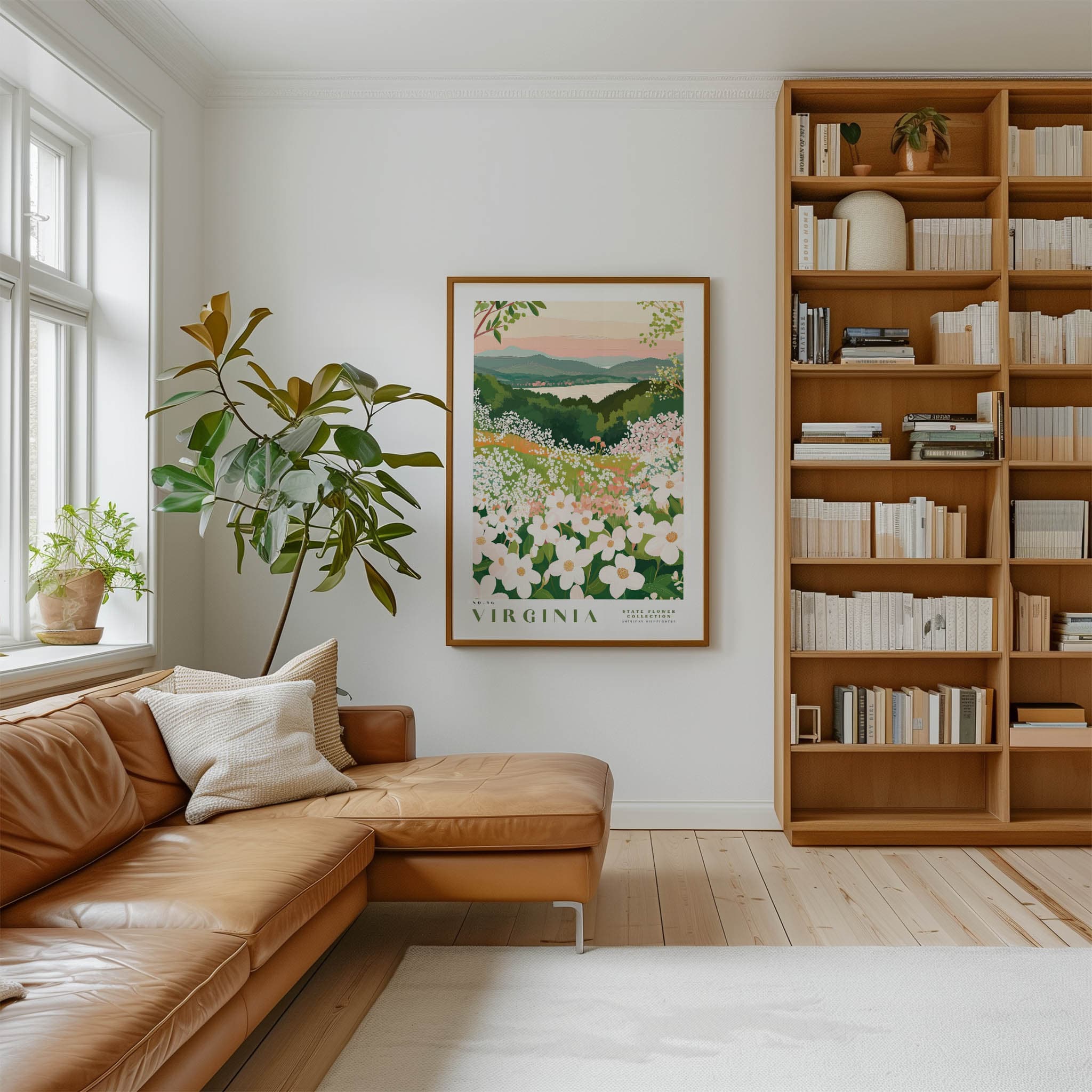 a cozy living room with a large window, a comfortable leather sofa, a wooden bookshelf filled with books, and a framed poster of a flowery landscape hanging on the wall.