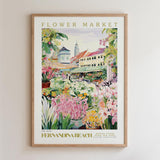 The image is a framed poster depicting a vibrant flower market in FERNANDINA BEACH, with colorful flowers, plants, and a picturesque town in the background.