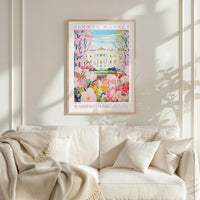 a framed poster of the Washington Monument, a famous landmark in Washington, D.C., with a vibrant floral scene surrounding it. The poster is hung on a wall above a white couch, creating a cozy and inviting atmosphere in the room.