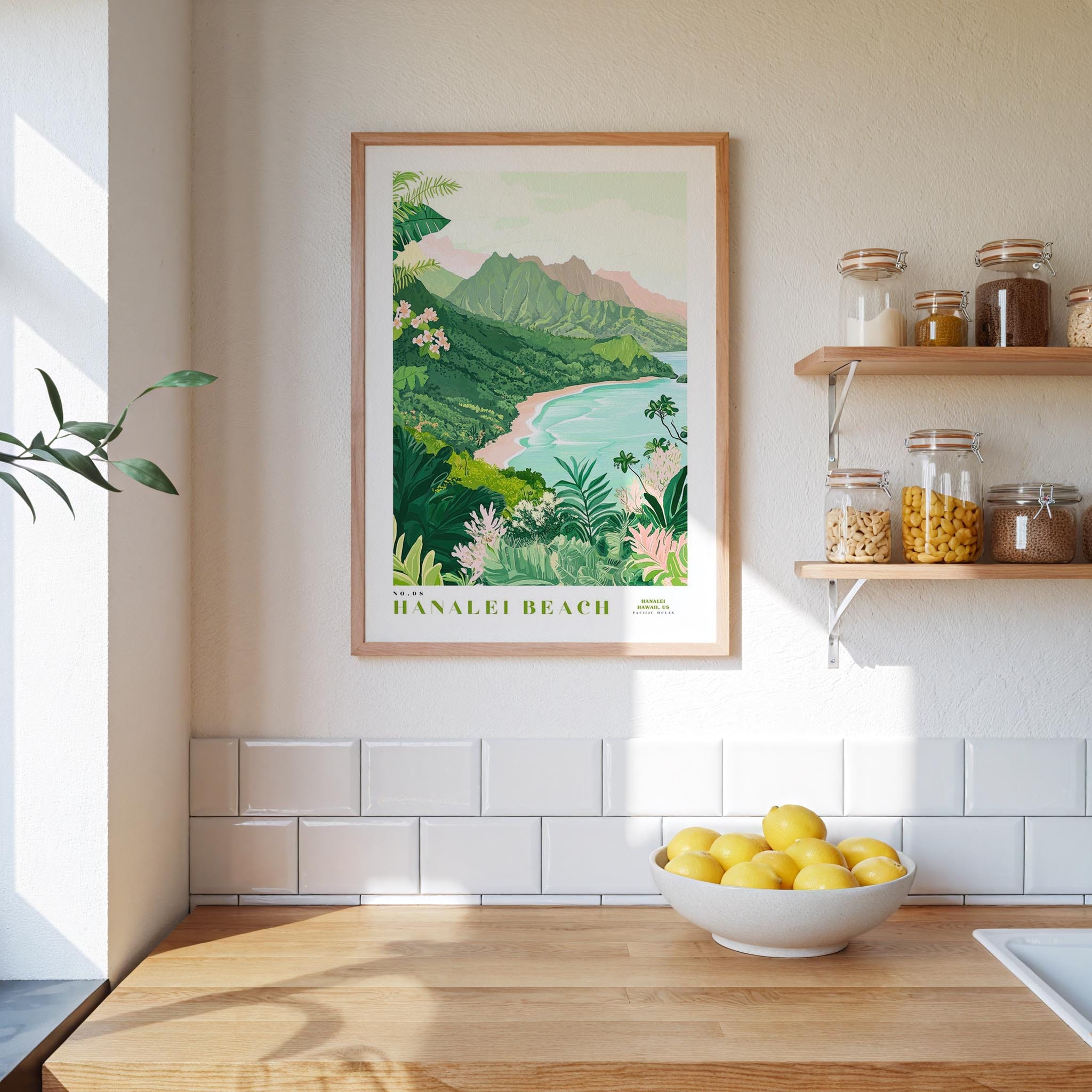 a kitchen counter with a bowl of lemons, a framed poster of Hanaole Beach, and a shelf with jars and bottles.