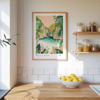a framed poster of a tropical beach scene with palm trees and a blue ocean, hanging on a wall above a wooden counter with a bowl of lemons.