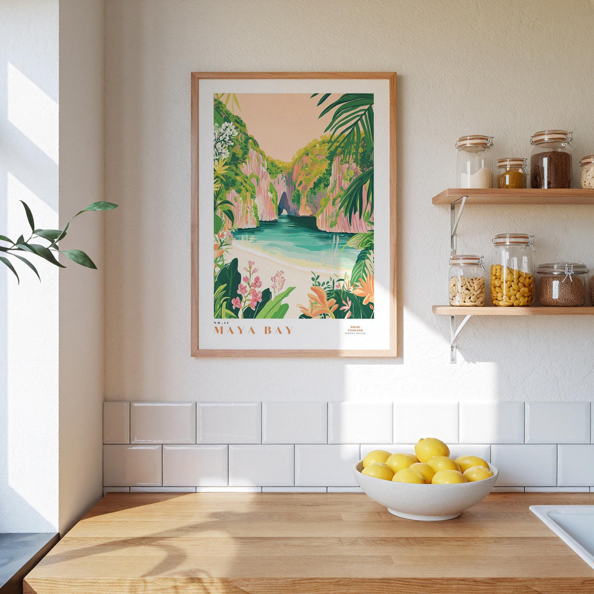 a framed poster of a tropical beach scene with palm trees and a blue ocean, hanging on a wall above a wooden counter with a bowl of lemons.