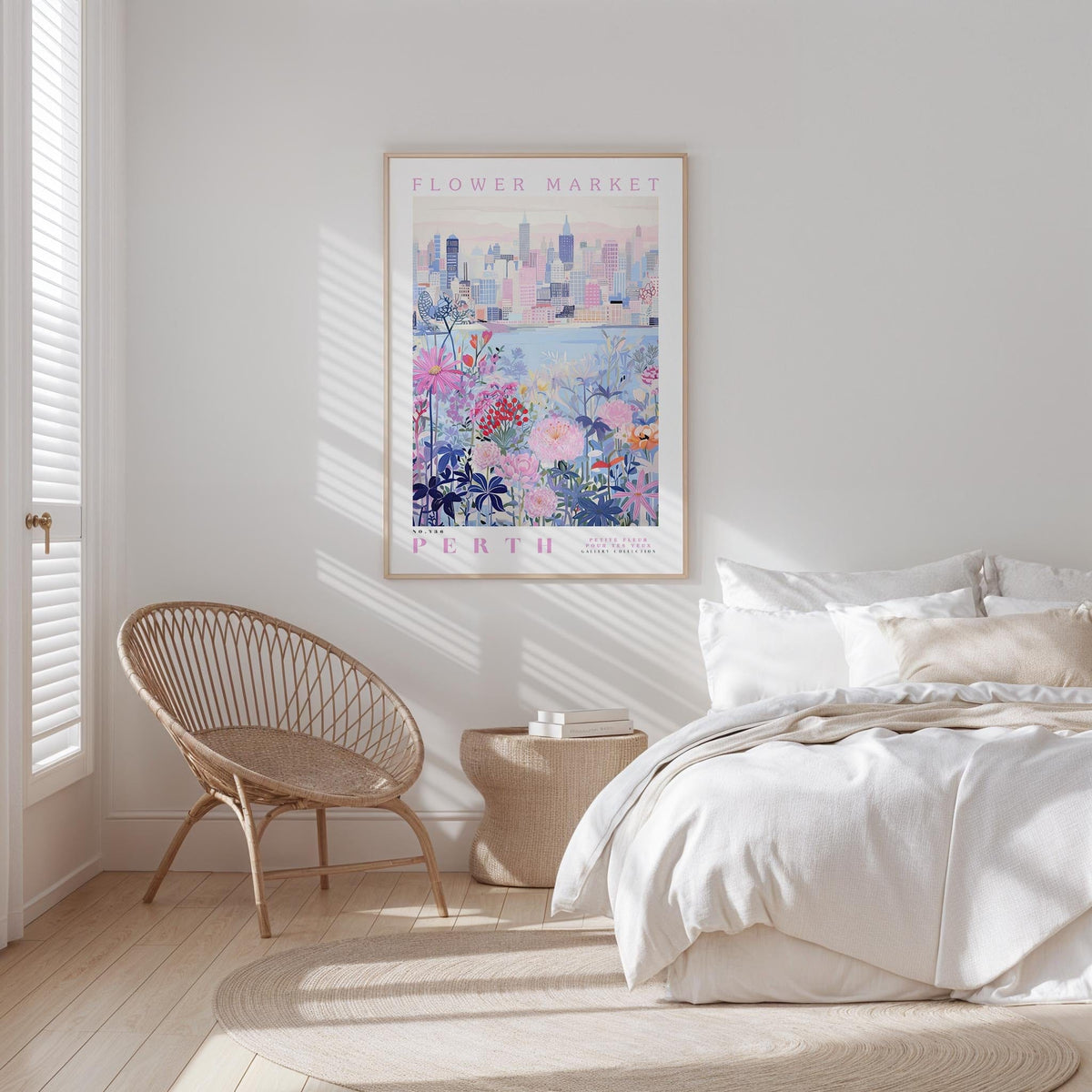 a bedroom with a bed, a woven chair, and a framed poster of a cityscape on the wall.