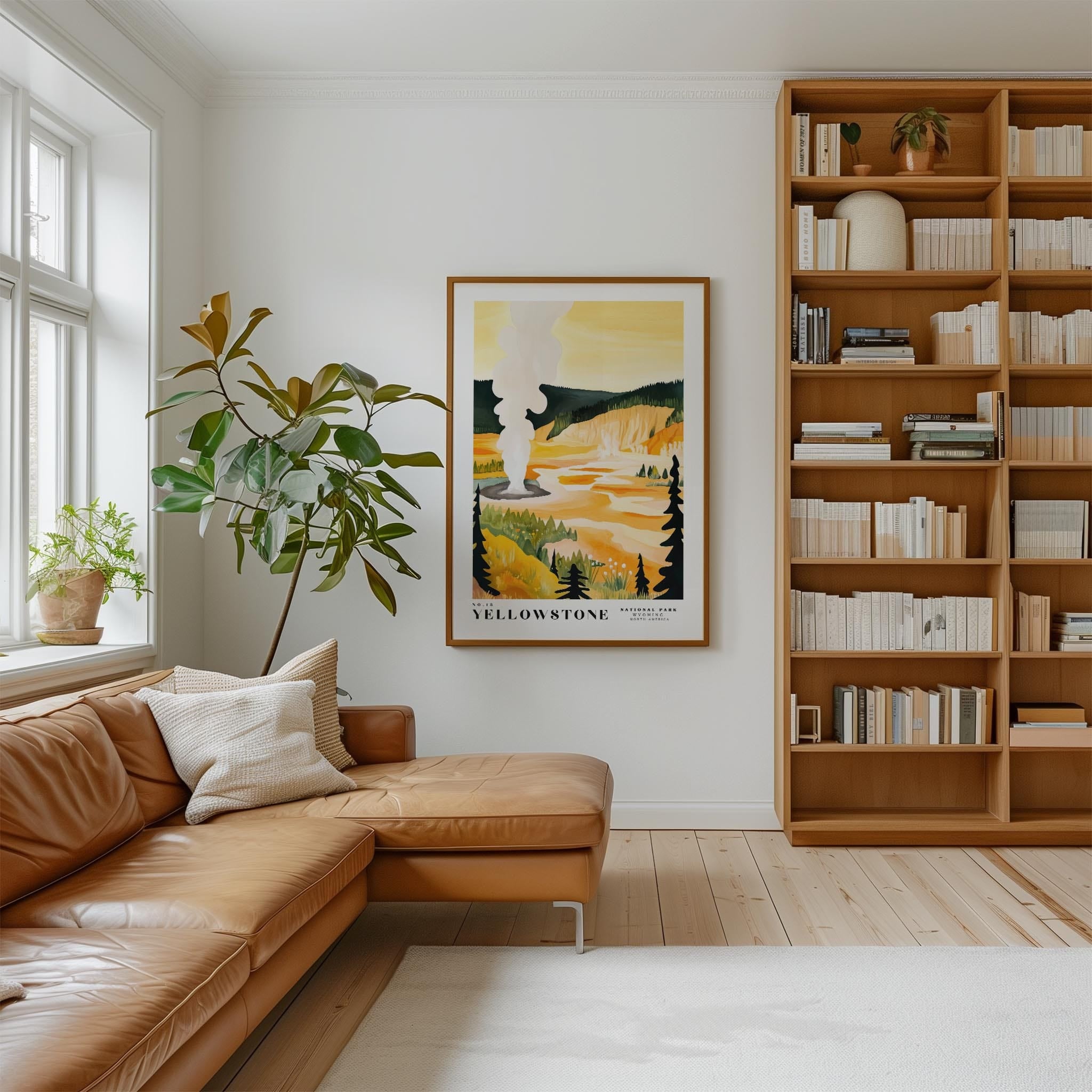 a cozy living room with a large bookshelf filled with books, a comfortable leather sofa, and a framed poster of a scenic landscape hanging on the wall.