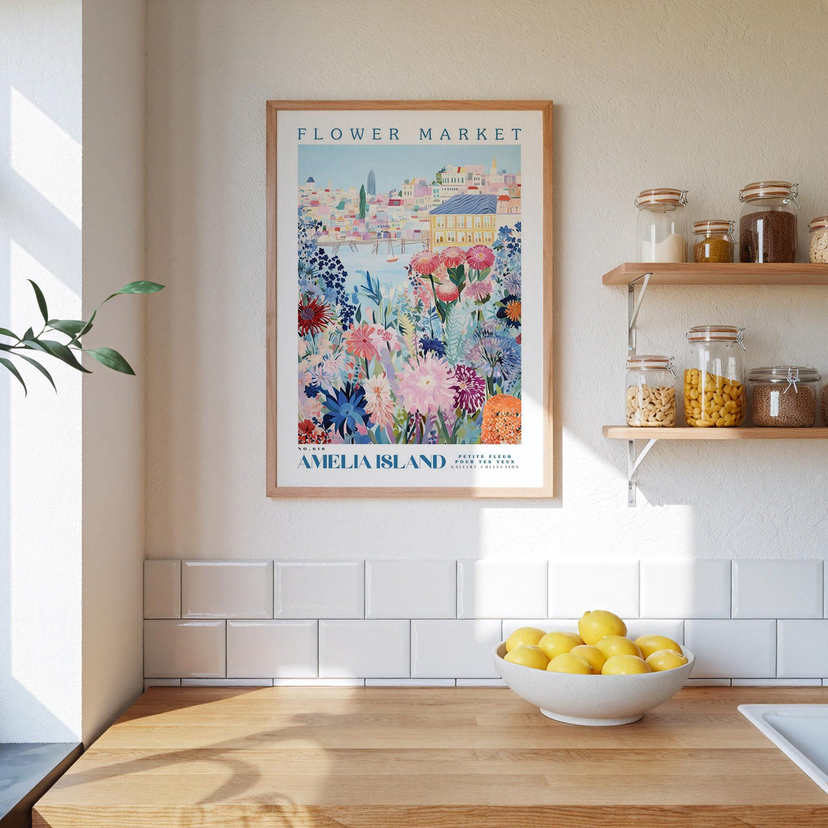 a kitchen scene with a framed poster of a colorful flower market on the wall, a wooden counter with a bowl of lemons, and shelves displaying various jars and containers.