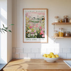 a framed poster of a flower market in Adelaide, Australia, hanging on a wall above a wooden counter with a bowl of lemons.