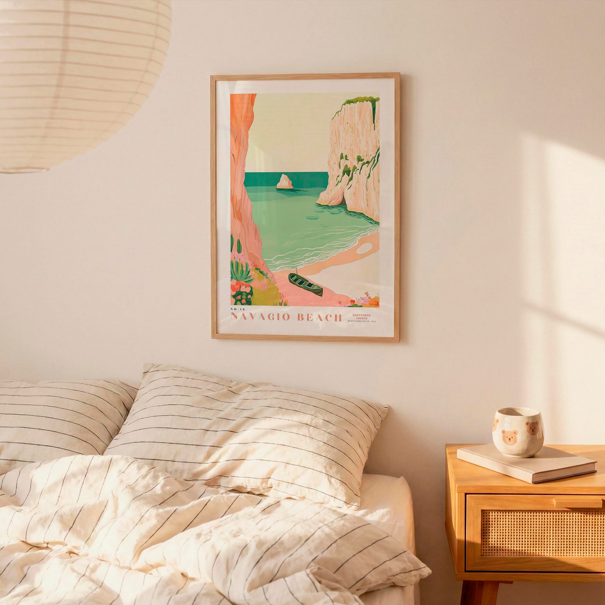 a bedroom with a bed, a nightstand, and a framed poster of a beach scene hanging on the wall.