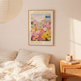 a bedroom with a bed, a nightstand, and a framed poster of a flower market on the wall.