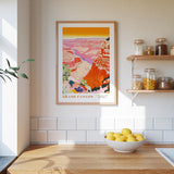 a kitchen counter with a bowl of lemons, a framed poster of the Grand Canyon, and various jars and containers on a shelf.