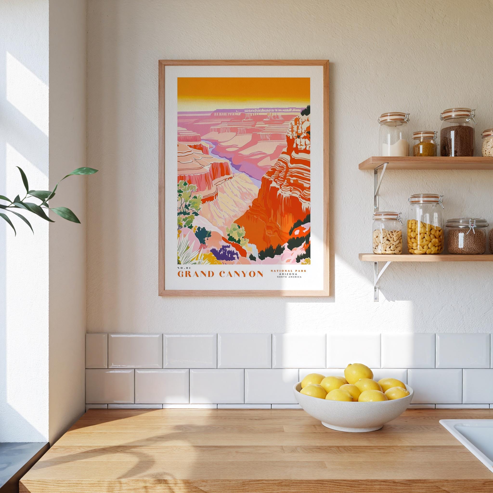 a kitchen counter with a bowl of lemons, a framed poster of the Grand Canyon, and various jars and containers on a shelf.