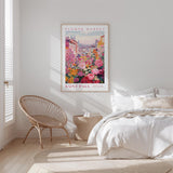 a bedroom with a large poster of a colorful floral scene hanging on the wall above a bed. The poster depicts a vibrant garden with various flowers and plants, creating a lively and cheerful atmosphere in the room.