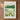 The image is a framed poster depicting a scenic landscape with mountains, a lake, and a field of flowers.