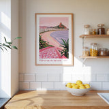 a framed poster of Copacabana Beach hanging on a wall above a kitchen counter with a bowl of lemons on it.