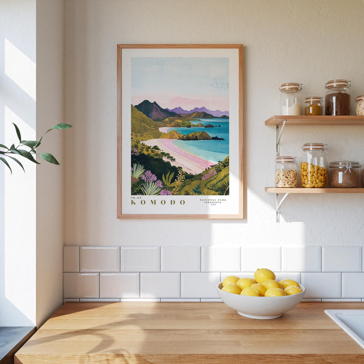a kitchen counter with a bowl of lemons, a framed picture of a coastal landscape, and various kitchen items such as jars and a plant.