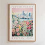 The image is a framed poster depicting a cityscape with a field of colorful flowers in the foreground.
