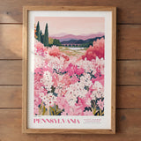 The image is a framed poster depicting a scenic landscape of a field filled with pink and white flowers, with mountains in the background.