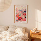 a bedroom scene with a framed poster of a cityscape and a bed with striped bedding.