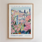 The image is a framed poster depicting a vibrant and colorful cityscape with various buildings, flowers, and plants.