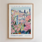 The image is a framed poster depicting a vibrant and colorful cityscape with various buildings, flowers, and plants.