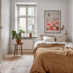 a cozy bedroom with a large bed, a nightstand with a plant, and a framed poster of the Seattle Flower Market on the wall.