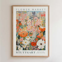The image is a framed poster depicting a vibrant and colorful floral scene, with various flowers and plants arranged in a visually appealing manner.